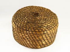 Round, basket like structure. Strands of straw coiled up on top of each other. Held together by darker, interwoven strands of straw. To magnify click now