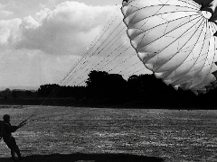 Paraglider holding a parachute.